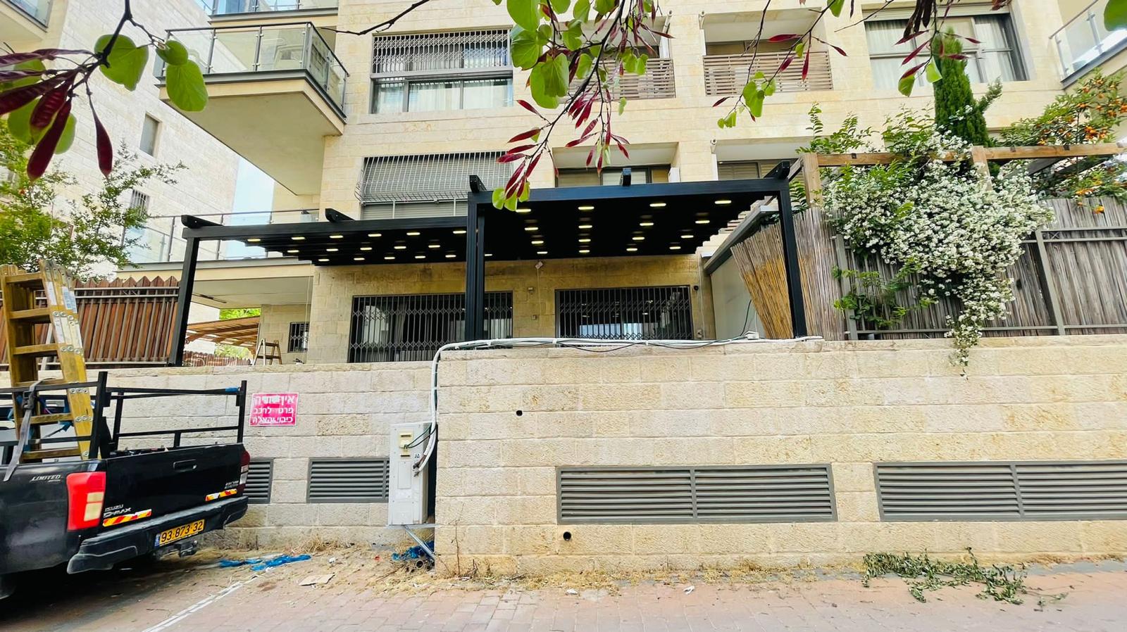 פרגולת אלומיניום שחורה עם תאורת לד משולבת — מבט חזיתי